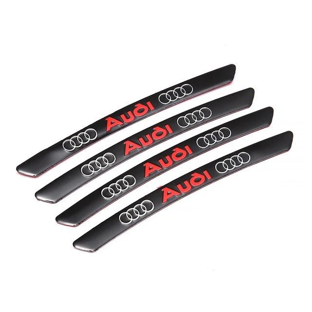 Four black wheel decals with red Audi lettering and silver-coloured rings.