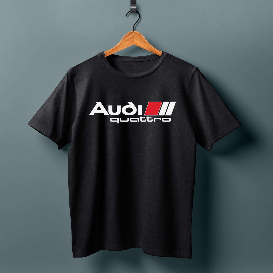 Black T-shirt on a wooden hanger with a white Audi quattro logo and red-and-white stripes.